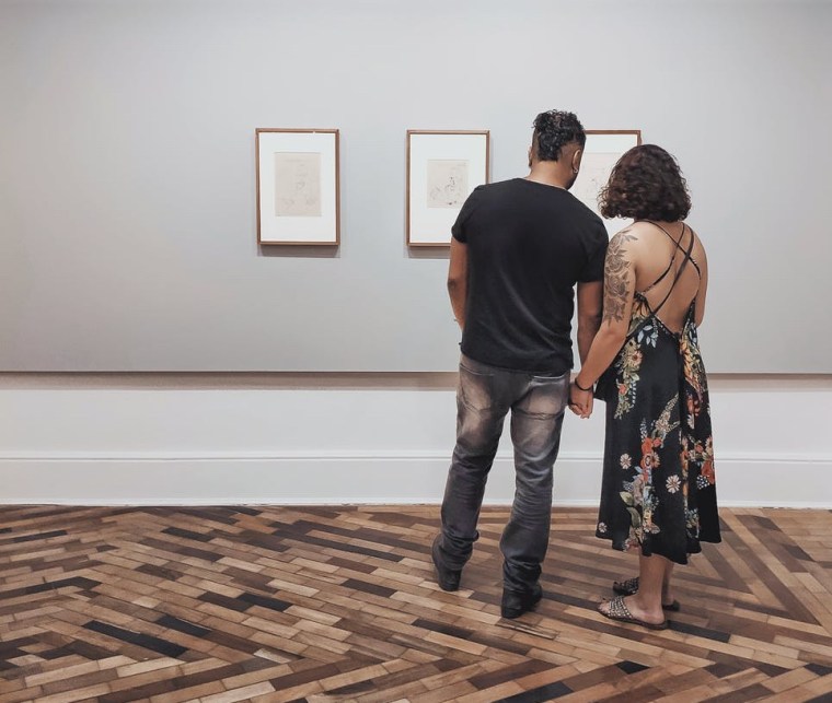 man and woman looking at wall decor inside building